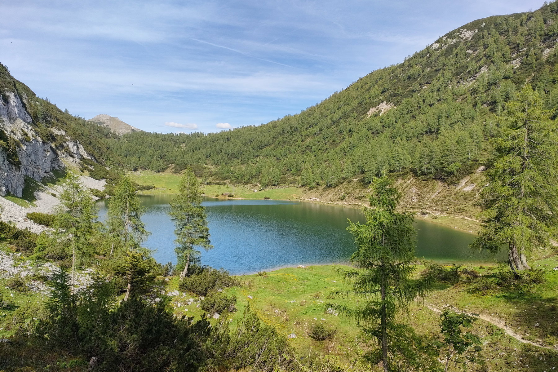 Rückblick zum Almkogel durch lichten Wald und vom Schwarzensee aus. Fotos: Manfred Hinteregger
